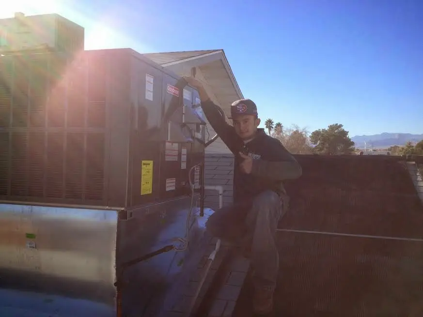 HVAC technician performing Air Duct Repair on a rooftop unit in Lake Holiday